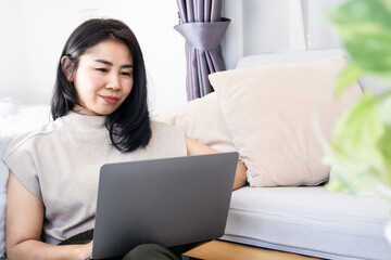Asian woman using computer  laptop , freelancer work online from home office , e- learning concept