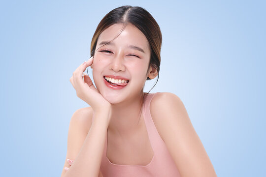 Close-up portrait of young Asian beautiful woman with K-beauty make up style and healthy and perfect skin isolated on light blue background for skincare commercial product advertising.