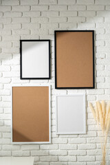 Varied Sized Photo Frames Displayed on a White Brick Wall