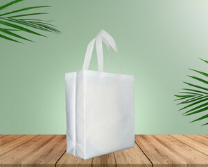 White Color Eco Friendly Tote Bag With Loop Strap. Non Woven Fabric Bag isolated on wood table with plants green background With copyspace for text