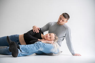 Intimate Moment of a Casual Couple Sitting Together on the floor on a Plain Background