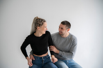 Joyful Couple Sharing a Laugh and fun Together at home against white wall