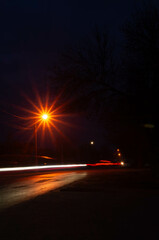 Night falls on a quiet street, its tranquility captured in the dance of light and shadow,...