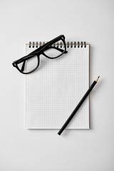 Notepad, pen and glasses on the table
