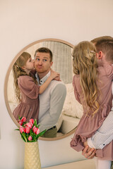 happy father with daughter reflection in the mirror