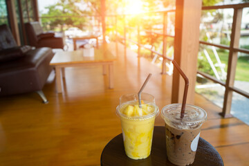 Ice Coffee and smoothie  in the cup and wrap with tissue in the coffee shop restaurant with green tree and sunlight  background. Sweet drinking and cool like lover in summer.