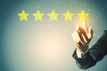 Close up of male hand pointing at 5 star rating on blurry background with mock up place. Customer...