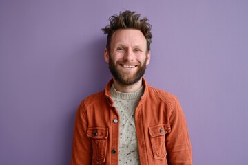 Portrait of a handsome young man smiling against a purple background. - obrazy, fototapety, plakaty