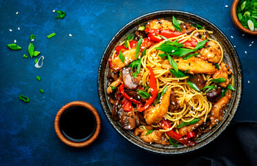 Hot stir fry egg noodles with turkey, paprika, mushrooms, chives and sesame seeds with ginger,...