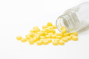 Yellow pills overflowing from the bottle
