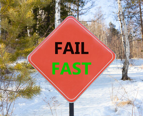 Fail fast symbol. Concept words Fail fast on beautiful red road sign. Beautiful forest snow blue sky background. Business and fail fast concept. Copy space.