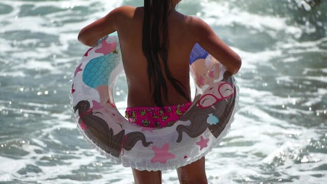 Summer Vacation Woman floats on an inflatable donut mattress, a water toy swim ring. Positive happy woman relaxing and enjoying family summer travel holidays vacation on the sea. Slow motion
