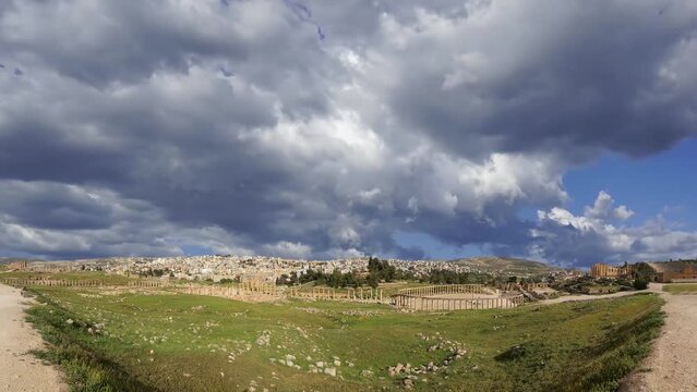 Roman ruins (against the background of a beautiful sky with clouds, 4K, time lapse, with zoom) in the Jordanian city of Jerash (Gerasa of Antiquity), Jordan  