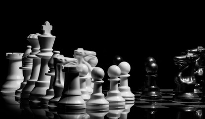 Close up of Chess pieces on a reflective mirror board surface wi