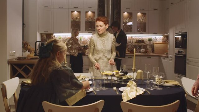 Slow motion shot footage of big family with kids wearing fancy clothes preparing to celebrate Christmas setting festive table at home