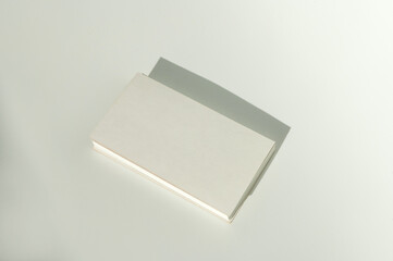 White blank business card on brown paper background with soft shadow.