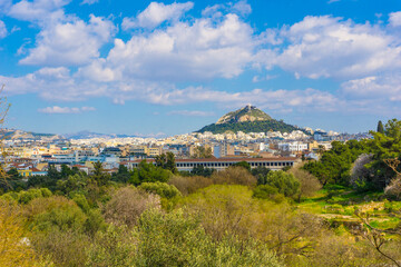 Panoramic view of the city of Athens, and the Lycabettus hill in Greece, as seen from the roman agora. The city unfolds in the background with iconic landmarks like the Attalos Stoa.
