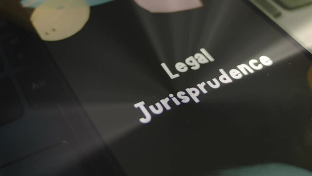 Legal Jurisprudence inscription on smartphone screen. Graphic presentation on black background with bokeh lights flickering . Light rays. Legal concept