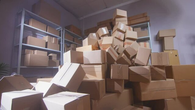 a piles of cardboard boxes against the background of a warehouse of shelving nobody
