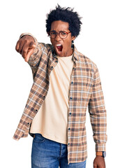 Handsome african american man with afro hair wearing casual clothes and glasses pointing displeased and frustrated to the camera, angry and furious with you