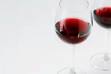 Fotobehang red wine in clear wine glass on white background copy space © id512