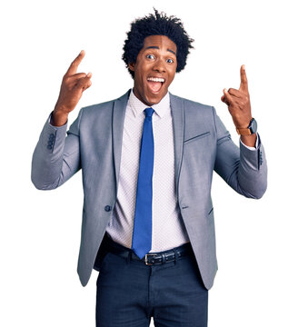 Handsome african american man with afro hair wearing business jacket shouting with crazy expression doing rock symbol with hands up. music star. heavy music concept.