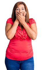 Middle age latin woman wearing casual clothes shocked covering mouth with hands for mistake. secret...