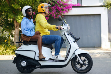 Happy Black woman using motorbike taxi service to ride around town