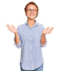 Young redhead woman wearing casual clothes and glasses celebrating mad and crazy for success with...