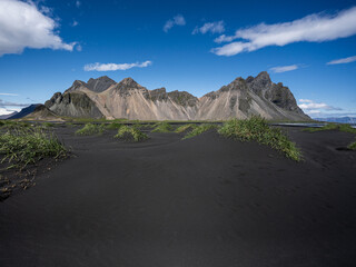 Grasbewachsene D&uuml;nen aus schwarzem Sand, vor dem Bergmassiv Vestrahorn in Stokksnes