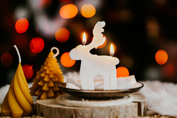 Cute deer shaped soy wax candle, Christmas lights in the background 