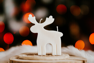 Cute deer shaped soy wax candle, Christmas lights in the background 