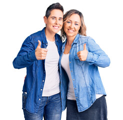 Couple of women wearing casual clothes success sign doing positive gesture with hand, thumbs up...