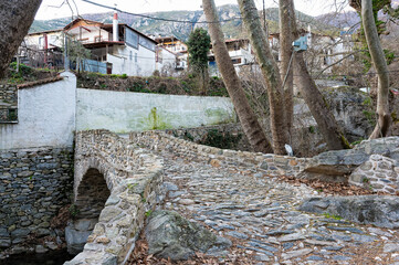 View of a traditional stone bridge at the village of Mesoropi in northern Greece in winter. - 774752360