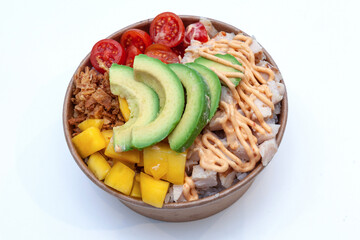 Takeaway poke bowl with fresh chicken, avocado, mango and vegetables in recycled kraft paper...