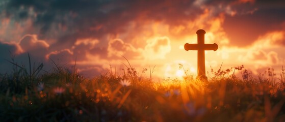 The silhouette of a christian cross on grass with miracle bright lighting is a religious and worship concept, set against a sunrise background