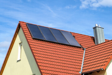 Rotes Hausdach mit Solarthermie-Kollektoren