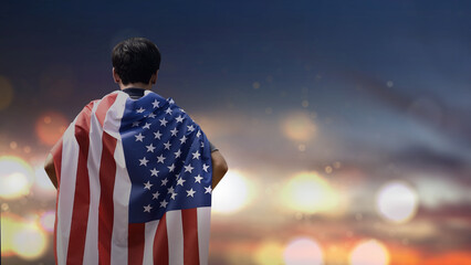 Young man earing the flag of the United States of America with copy space.
