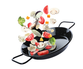 Frying pan with fresh ingredients in air on white background