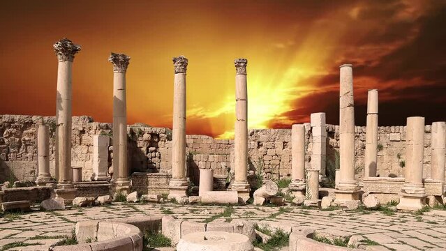 Roman ruins (against the background of the sunset, 4K, time lapse, with zoom) in the Jordanian city of Jerash (Gerasa of Antiquity), capital and largest city of Jerash Governorate, Jordan