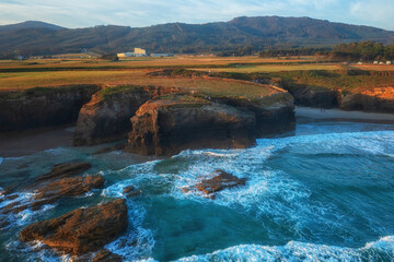 Aerial view of the Cathedrals beach (Playa de las Catedrales) or Praia de Augas Santas at sunrise, amazing landscape with rocks and Atlantic Ocean, Ribadeo, Galicia, Spain. Outdoor travel background