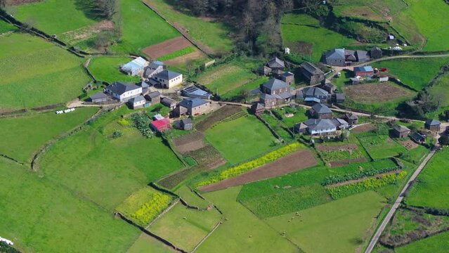Houses On Field In Spanish Village In A Fonsagrada, Lugo, Spain. aerial pullback shot