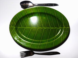 Empty green plate leaf pattern theme with spoon and fork isolated white background