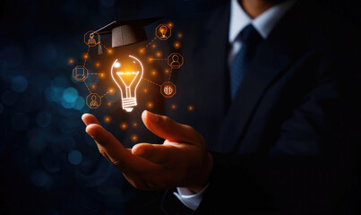 A businessman holds a light bulb with a graduation hat and glowing icons representing education, knowledge sharing, or online learning on a black background, in the style of a training course © Michael