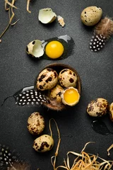 Foto op Plexiglas Close-up of quail egg yolk and quail fresh eggs. On a black stone background. Top view. © Yaruniv-Studio