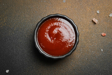 Ketchup sauce or tomato paste in a black sauce pan. Sauces for meat.