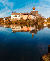 High resolution stitched alpine winter panorama of a monastery with reflections on a sunny winter...