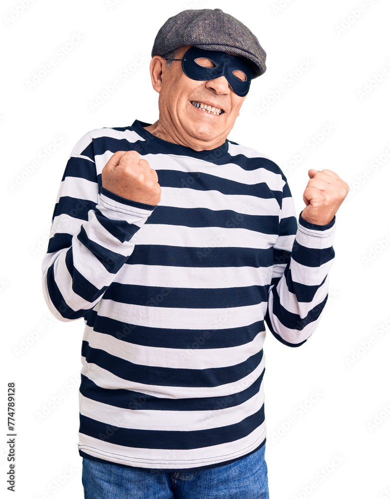 Poster Senior handsome man wearing burglar mask and t-shirt very happy and excited doing winner gesture with arms raised, smiling and screaming for success. celebration concept.