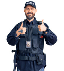 Young handsome man wearing police uniform success sign doing positive gesture with hand, thumbs up smiling and happy. cheerful expression and winner gesture.