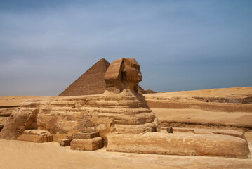 Great Sphinx in front of Pyramid of Cheops (Khufu). Giza Pyramid Complex is complex of ancient...
